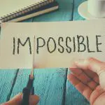 The Power of Positivity: How positive thinking changed my life. Image of man cutting IM from the word Impossible to make the word read possible