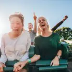 Confessions of a control-freak: How to manage a fear of losing control. Enthusiastic young friends riding amusement park ride