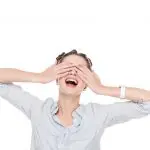 10 ways to slow signs of ageing around your eyes without using an eye cream. Image of smiling girl covering eyes with hands isolated on white