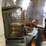 48 Hours in Budapest: Image of Chimney Cakes being baked on skewers with wooden handles in a special oven