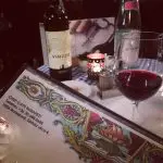 48 hours in Budapest. Image of a table in the Chef Cafe Budapest, with the menu, a bottle of red wine and table water in the background and a glass of red wine by the menu