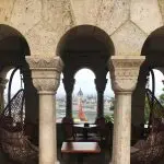 5 Things to do in Buda, Budapest. Image of view into cafe at Fisherman's Bastion with a through view of Pest and the Parliament building in the background