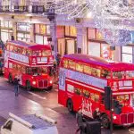 Happy Days: London Afternoon Tea Bus Tour. Image of Afternoon Tea Tour buses on a London high street with the Christmas lights above