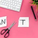 Understanding yourself: How EMDR Therapy helped me develop as a person. Image of a keyboard, glasses, coffee cup and saucer, plant and pen with a pair of scissors cutting through the word I Can't to become I can on a pink background