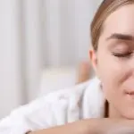 benefits of a spa day and spa tips. Image of Close up of half of female face. Serene young woman is lying at wellness center with relaxation.