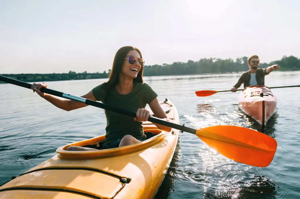 Let's give it a go: becoming more open to new experiences. Image of couple kayaking together on a lake and smiling having fun