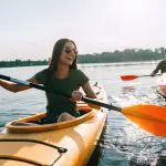 Let's give it a go: becoming more open to new experiences. Image of couple kayaking together on a lake and smiling having fun