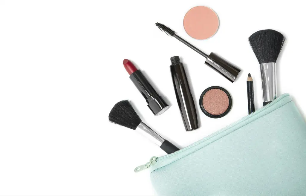 How to do your makeup in only 5 minutes. Image of peppermint makeup bag with various makeup products and brushes coming out of it