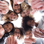 Feeling good for doing good: Why volunteering benefits everyone. Image of a group of females wearing grey t-shirts saying volunteer, smiling and pointing at the camera