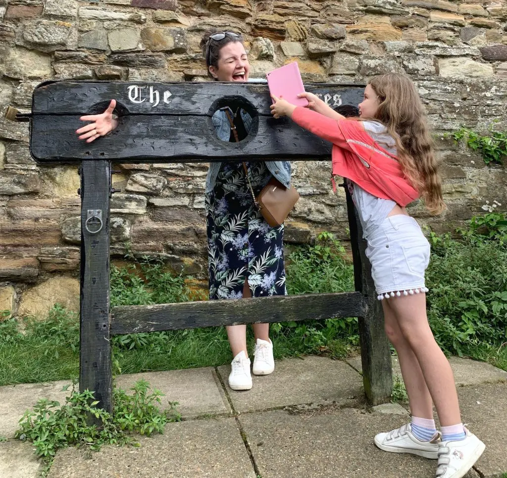 Stopping to try out the old stocks in Rye whilst on our Treasure Trails adventure