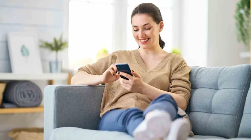 happy woman looking at her phone with no news anxiety