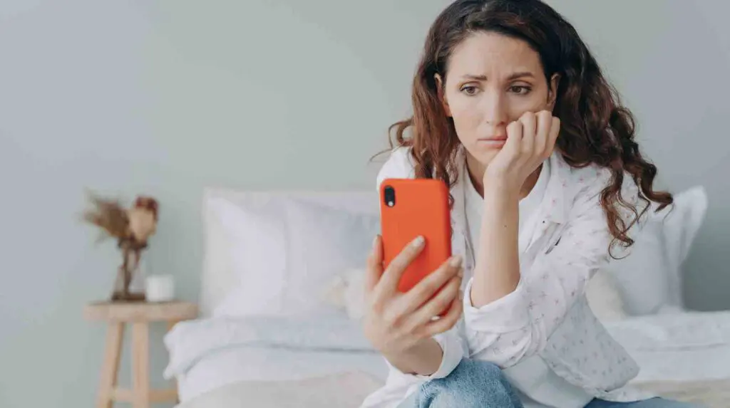 woman sat on her bed doomscrolling