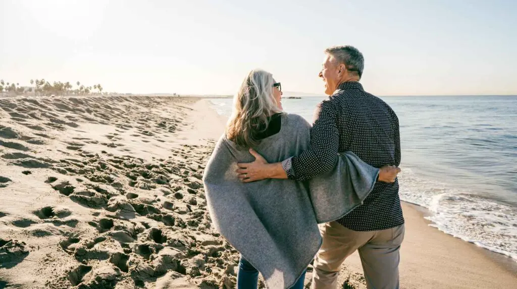 How to rebuild your life following a serious accident. Happy couple supporting each other walking along the beach