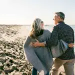 How to rebuild your life following a serious accident. Happy couple supporting each other walking along the beach