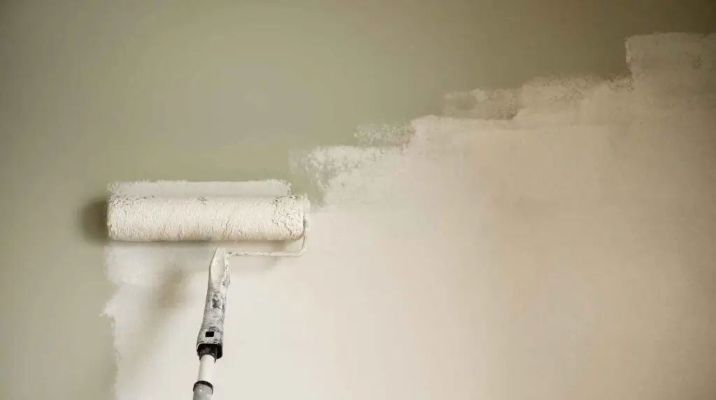 Roller painting a wall