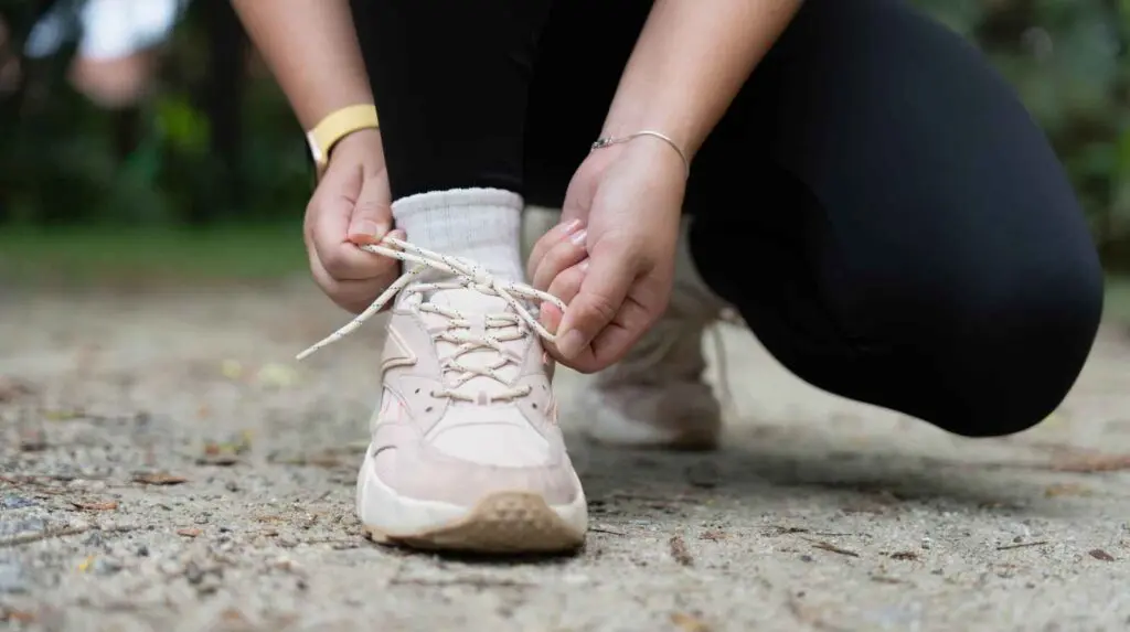 Woman tying up her running shoe laces. Healthy Habits concept