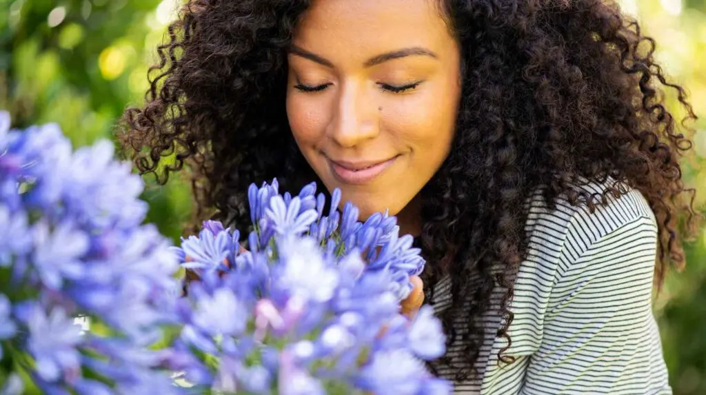 Woman smelling flowers. Concept of how different scents affect mood