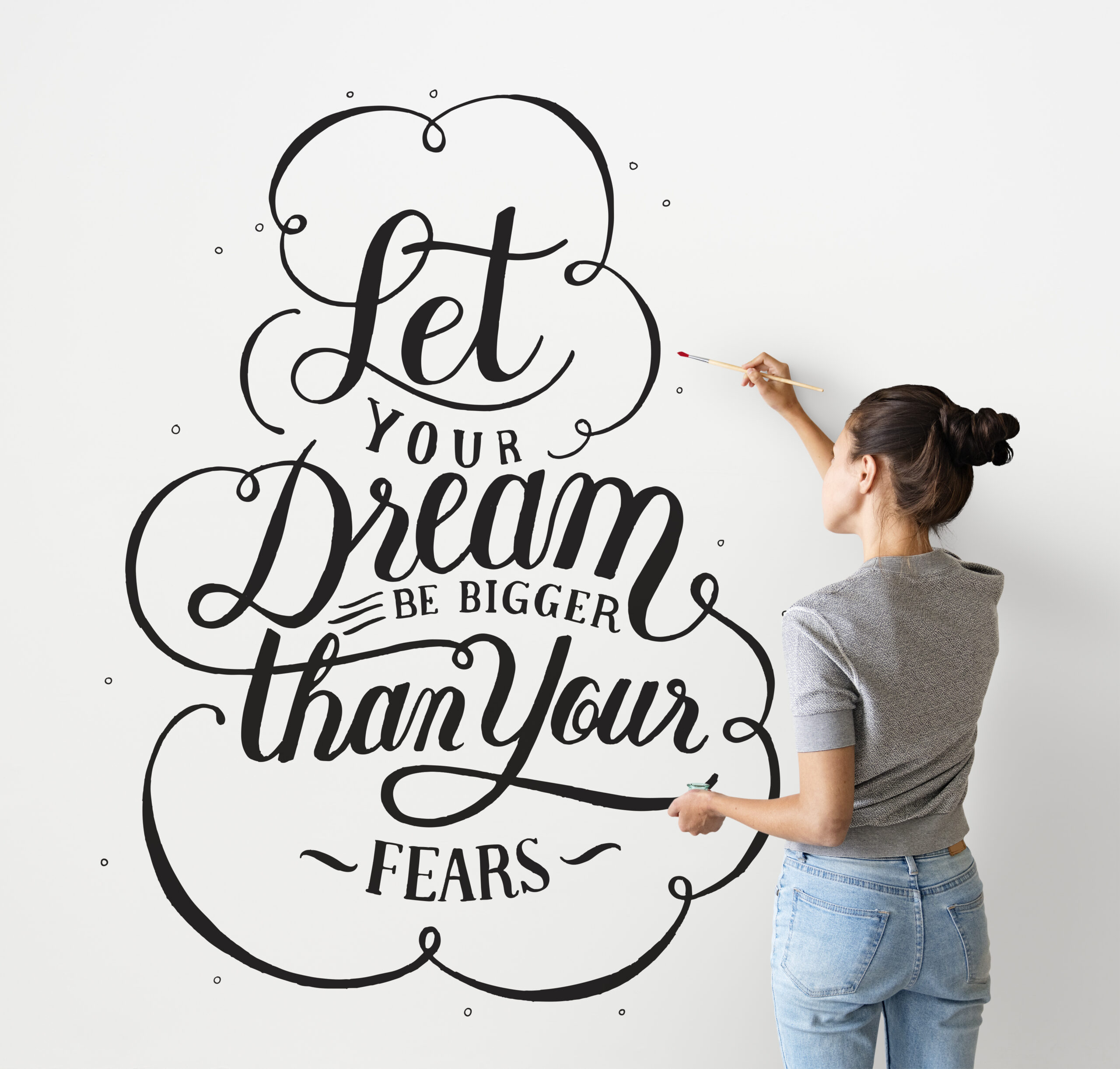 How to be more positive - Female artist writing a life motivation quote on the wall