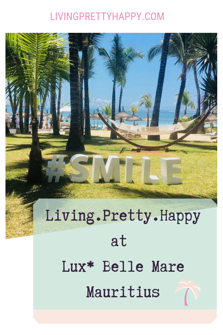 Living.Pretty.Happy at Lux* Belle Mare Mauritius. Pinterest graphic with image of palm trees in Mauritius with a hammock and a sign on the grass reading #smile.