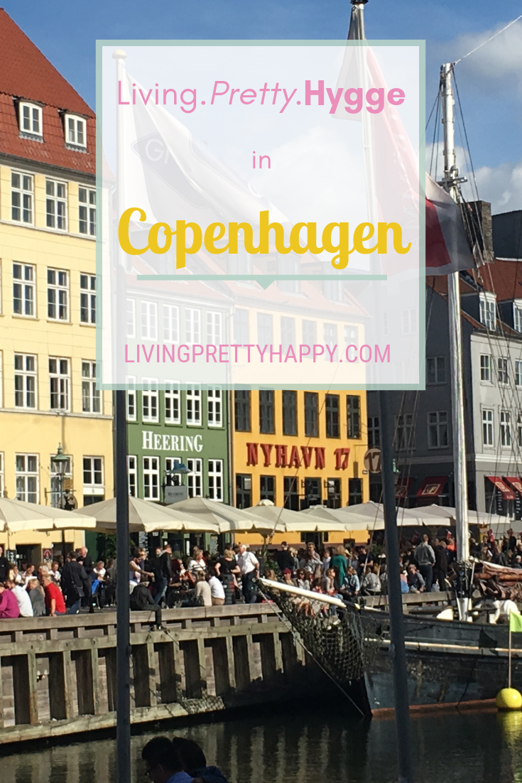 Living.Pretty.Hygge in Copenhagen. Pinterest graphic displaying post title on a background picture of Nyhavn harbour Copenhagen. Livingprettyhappy.com
