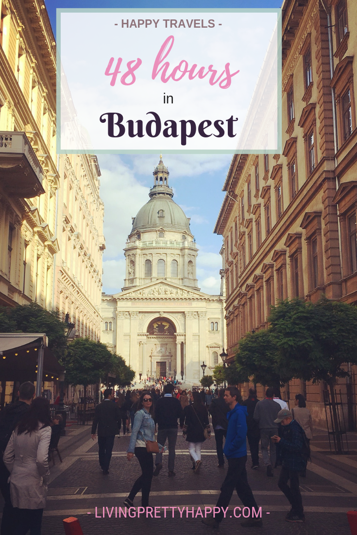 48 hours in Budapest: Pinterest graphic displaying post title on a background image of a street leading to St Stephen's Basilica Alex Grace can be seen in the foreground. Livingprettyhappy.com happy travels