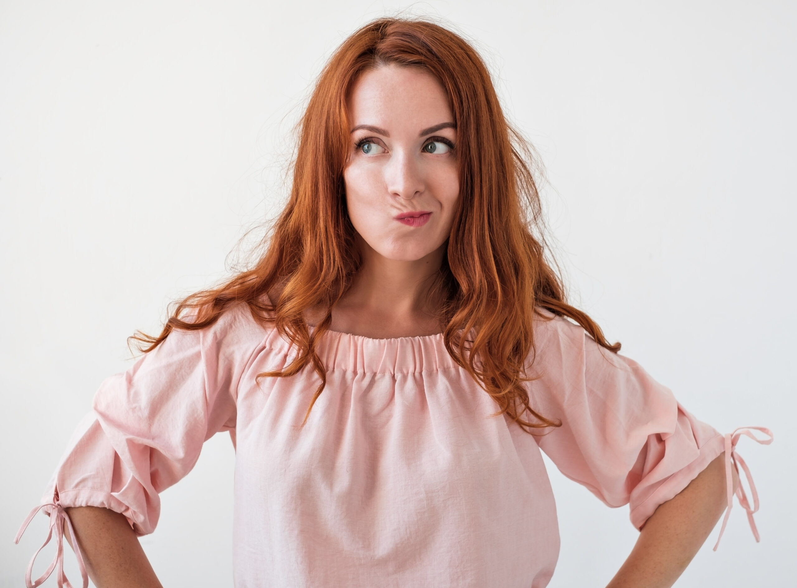 Improving well-being: The key to being happy? Image of a young woman posing with a thinking face as if considering the answer to a tricky question