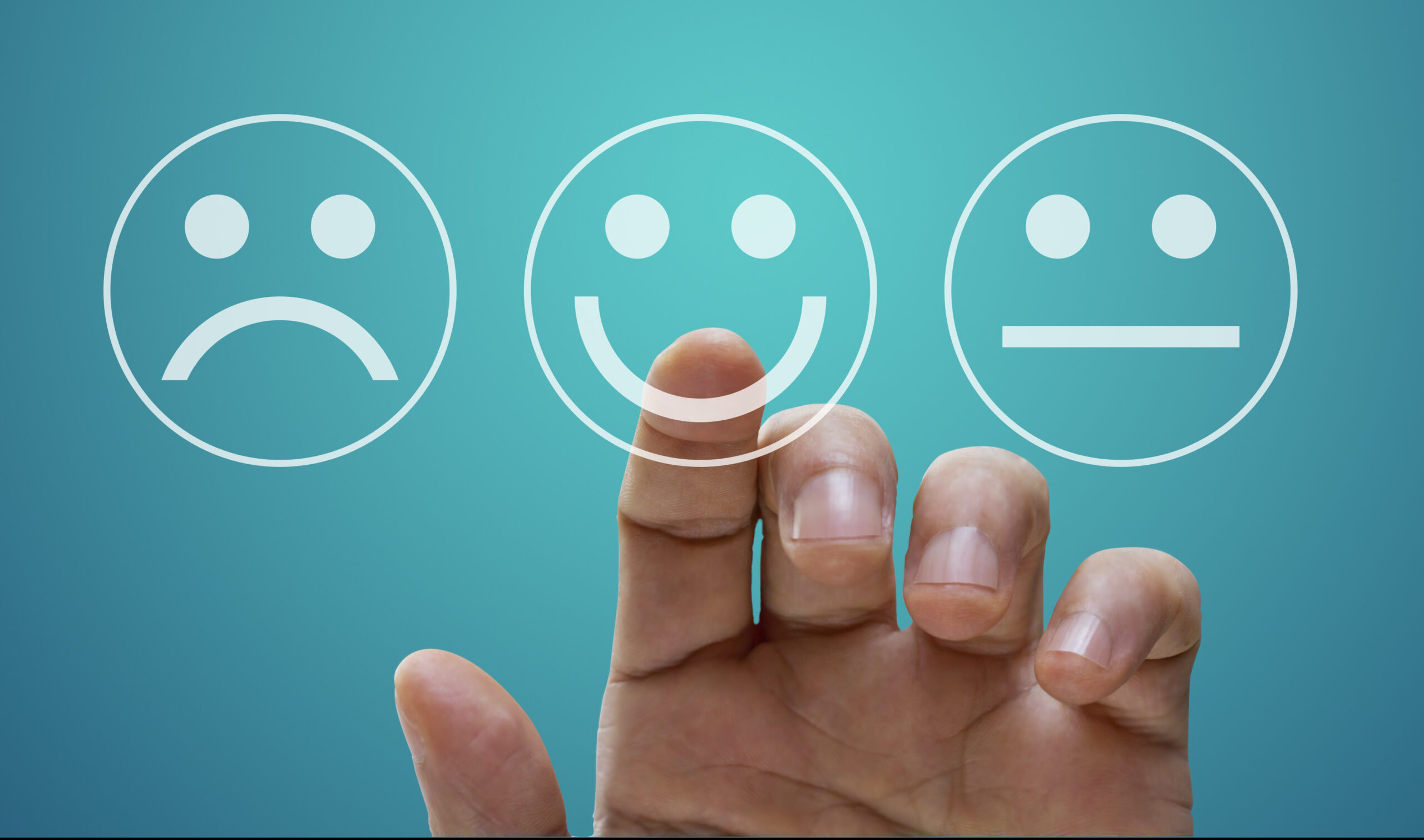 Improving well-being: The key to being happy? Image of 3 emoticon faces, unhappy, happy and unsure/OK a hand is held up about to select the happy emoticon