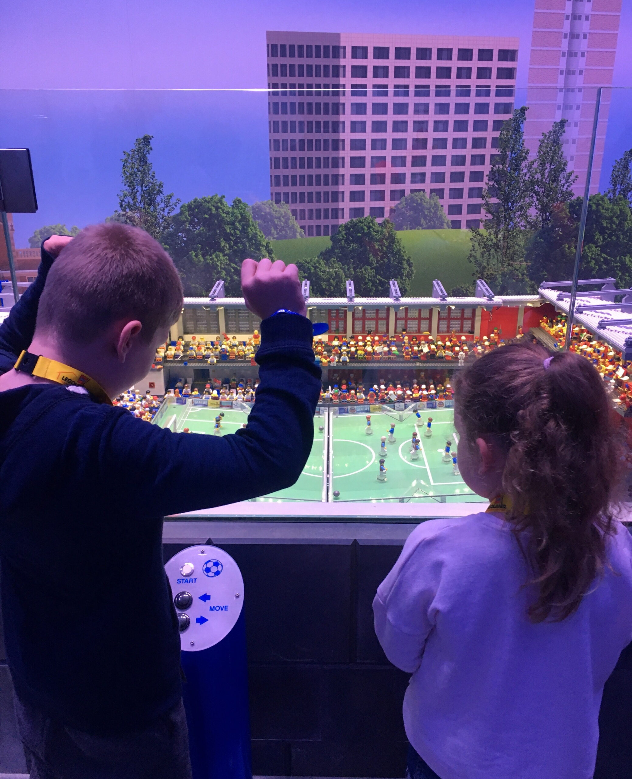 Happy Days: Legoland Discovery Centre Birmingham. Image of a young boy and girl looking at the Miniland football match at Legoland Discovery Centre Birmingham