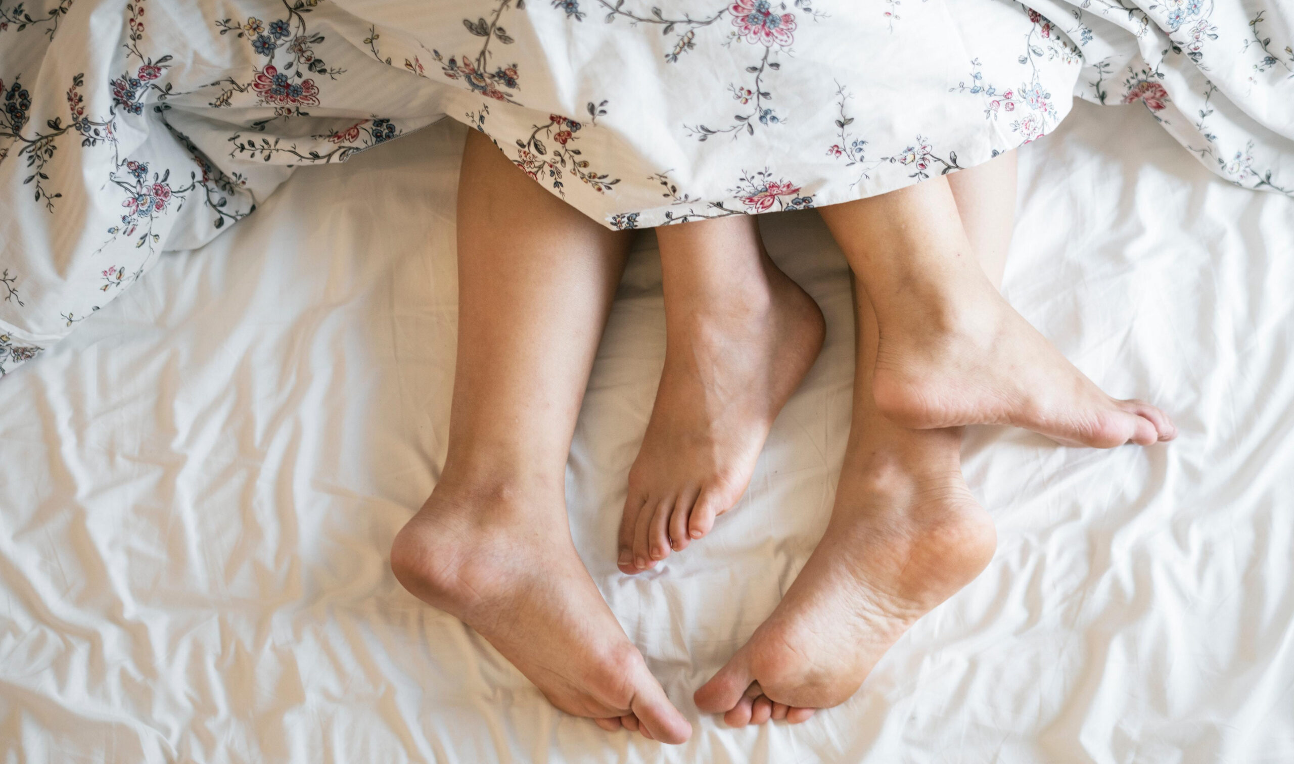 Exercise Hacks: How to be fitter without really trying. Couples barefeet protruding from under duvet cover