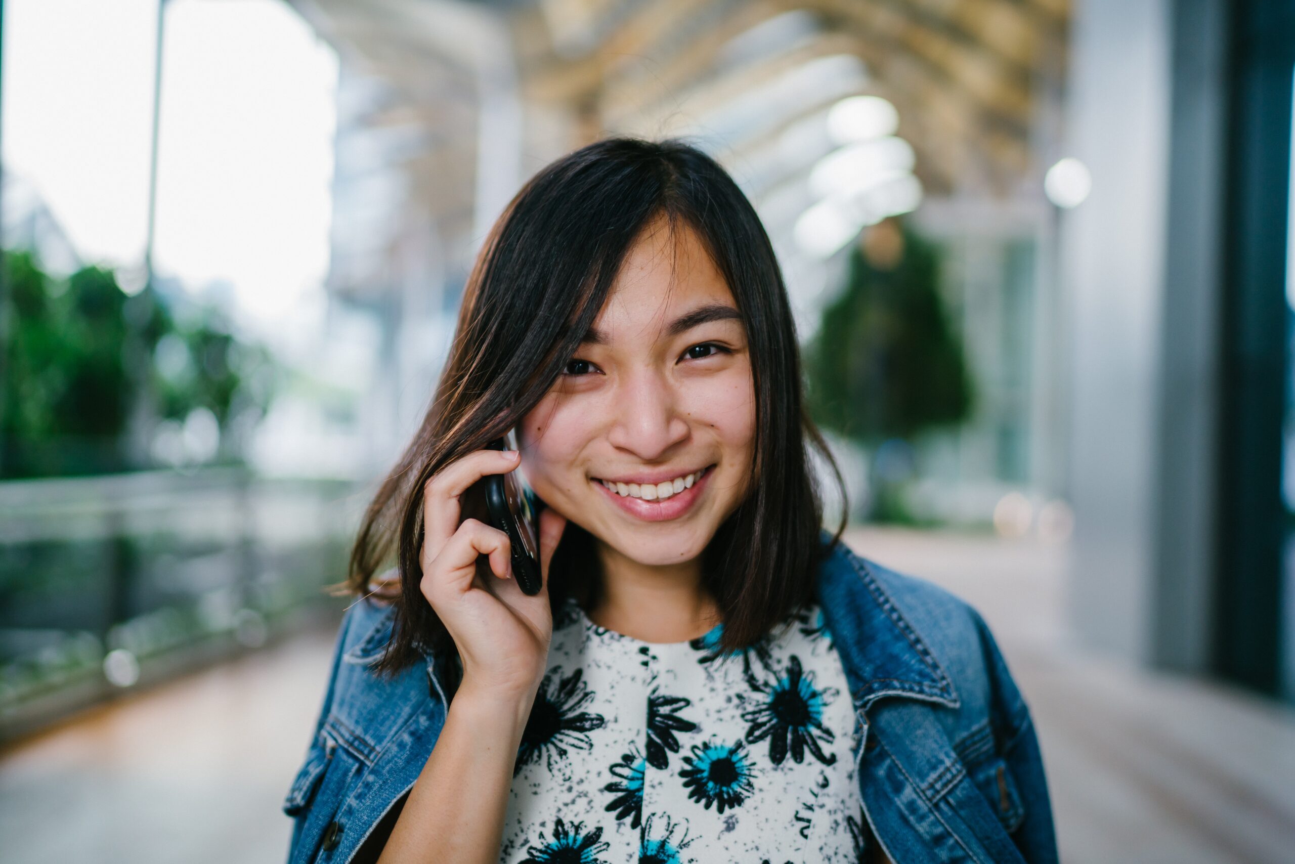 Exercise Hacks: How to be fitter without really trying. Image of young woman walking, smiling and talking on the phone