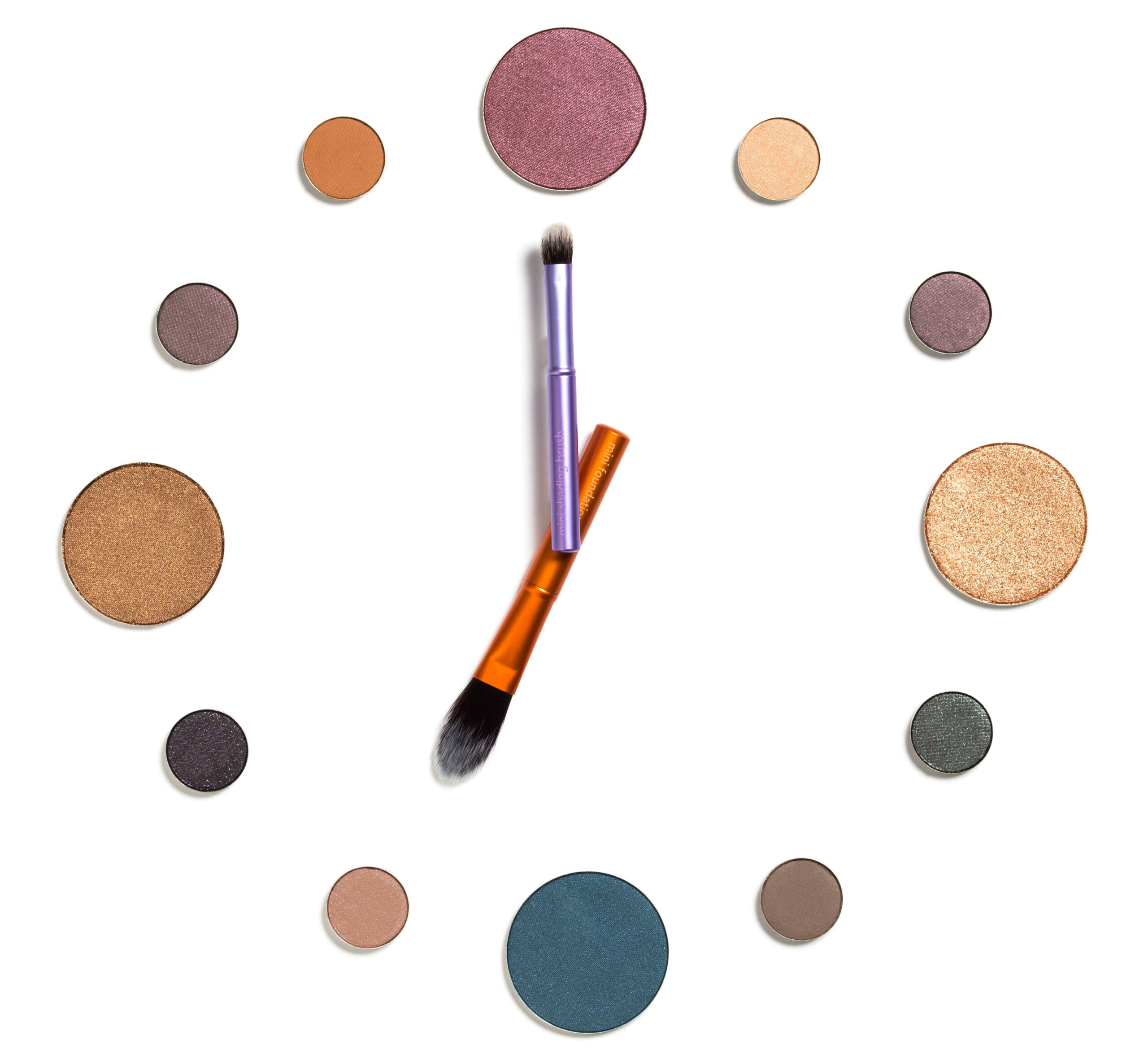 5 minute makeup. How to do your makeup in only 5 minutes. Image of eyeshadows and 2 makeup brushes laid out in a style to ressemble a clock