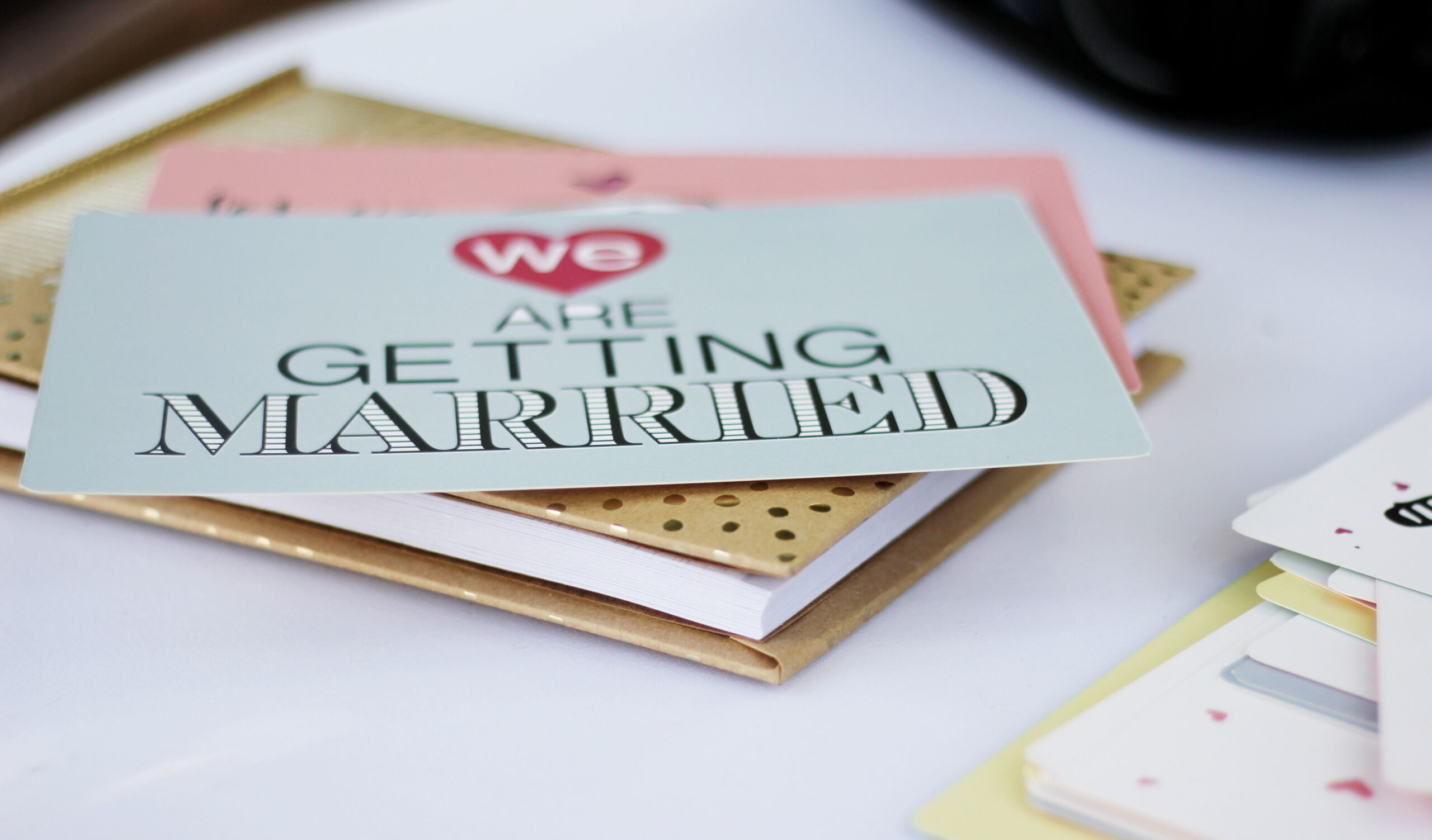 4 Tips to reduce wedding planning stress. Image of wedding stationary with the words we are getting married on one of the cards