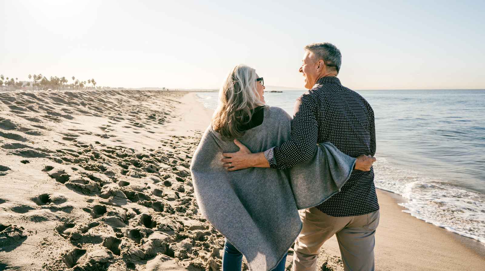 How to rebuild your life following a serious accident. Happy couple supporting each other walking along the beach